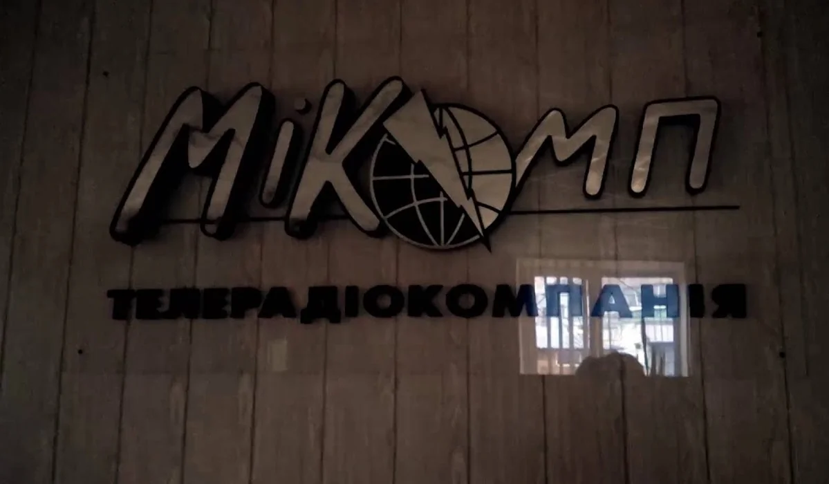 Обʼємна вивіска МіКомп із глобусом і блискавкою на деревʼяній стіні